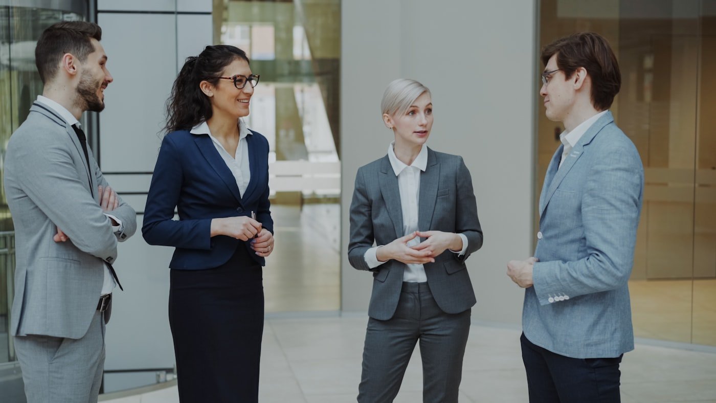 Team of professionals conversing in a modern office lobby